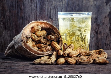Peanuts and beer on wood background