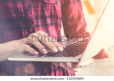 Close up of elegant woman's hand typing on her computer keyboard. Concept of working with information. Toned image