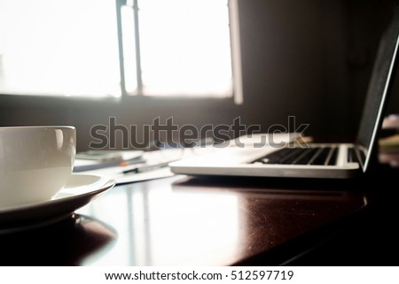 Business concept with copy space. Office desk table with cup of coffee focus and analysis chart, computer, notebook, pen on desk.Vintage tone Retro filter, selective focus.