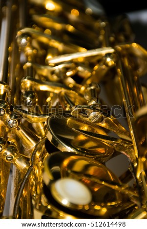 Beautiful golden saxophone with musical notes on wooden background, close up blur