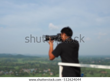 Man of photographers holding camera. blurred blur