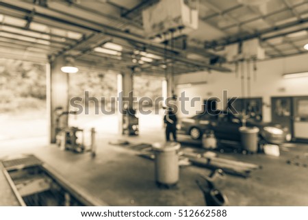 Blurred image of car in auto shop. Defocused background of modern repair shop. Small car oil change service station at Little Rock, Arkansas, US. Repair shop with working auto mechanic. Vintage filter