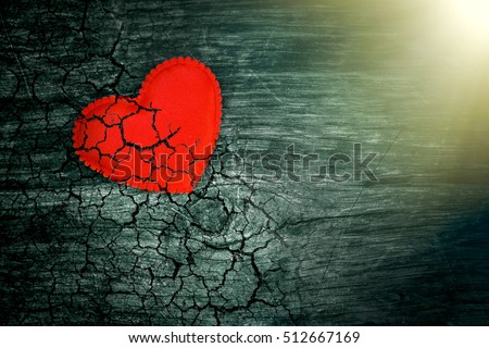 Decorative heart on dark wooden background with bright white light from the window. The concept of fading love. The end of life. On the verge of death. The aging of the human body. Heart disease. Royalty-Free Stock Photo #512667169