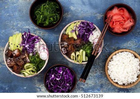 Hawaiian tuna poke bowl with seaweed, avocado, red cabbage slaw, radishes and black sesame seeds. Top view, overhead, flat lay