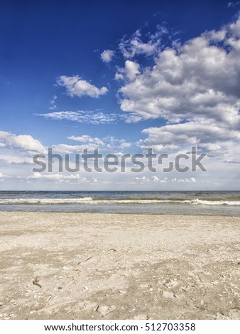 Solitary wild beach with sea shells on the shores of Black Sea at Corbu in Constanta county, nearby Danube Delta Reserve, Dobrogea, Romania on a beautiful summer day with blue sky and white clouds