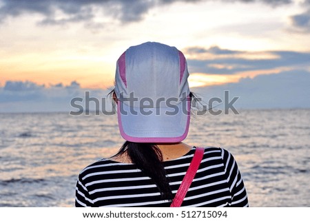The girl looking the sunset near the sea 