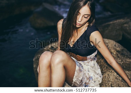 Fashion portrait of a girl model at night on the beach