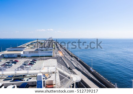 panoramic bird eye top aerial view with beautiful sea level with highway road under dramatic clear glow and fantasy blue sky in Umi Hotaru parking area island Tokyo bay aqua line, Japan
