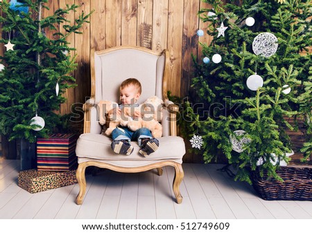 Happy little boy playing near the Christmas tree