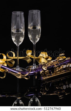 Music night with violet saxophone and two glasses of white wine on black background