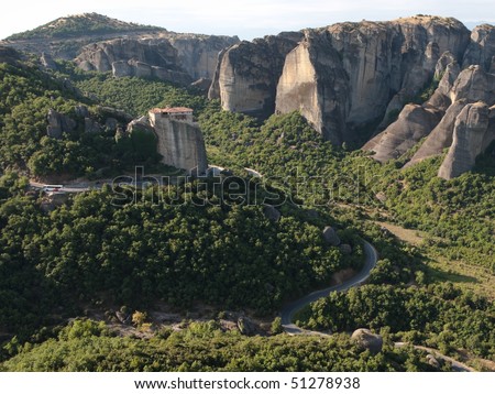 winding road crosses the landscape of the Meteora to go to the Roussanou monastery