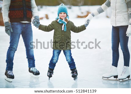 Smiling boy skating with parents