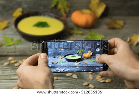 Food photography of Winter Pumpkin Soup on wooden background by smartphone for social media. Home made food photo for social networks. Top view mobile phone photo of pumpkin soup.