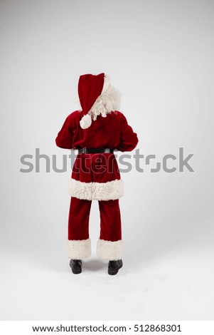 Santa Claus in eyeglasses and red costume on white background. Medium long shot