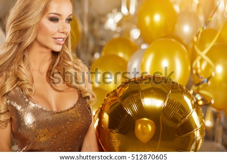 portrait of blond young woman between golden balloons and ribbons with a sweet smile