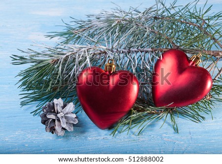 Two fur-tree toy - heart against the background of Christmas tree branches