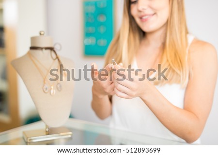 Closeup of a cute young woman trying to sell a diamond ring at a jewelry and fashion shop