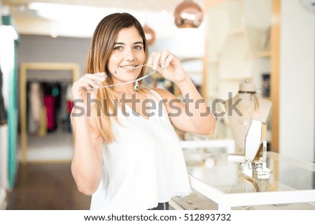 Portrait of a gorgeous young woman showing her favorite necklace at a jewelry store