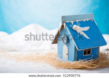 Gingerbread house. Christmas pastries. Gingerbread in the snow. In the background a blue sky with copy space.