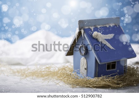 Gingerbread house. Christmas pastries. Gingerbread in the snow. In the background a blue sky with copy space.