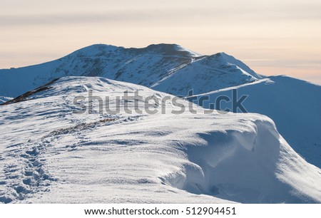 Snowy landscape in the mountains. Road and snowy ledge. Mount Stiy, Ukrainian Carpathians. Royalty-Free Stock Photo #512904451