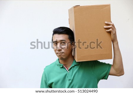 friendly Asian man wearing green casual shirt holds packaging box for transport and delivery business on white background