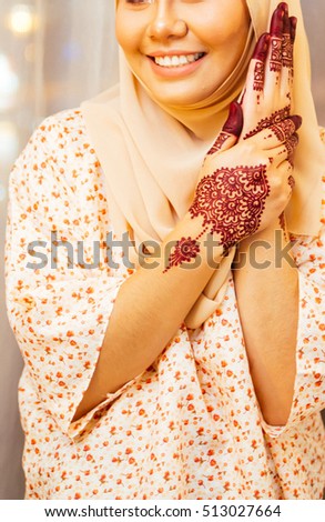 unidentified malay woman posing with henna design on hand.  Henna design on hand is typical for malay wedding reception