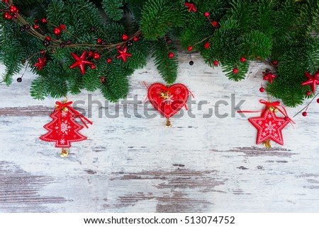 christmas fresh evergreen tree branches with red vintage heart, christas tree and star decorations on white aged wood