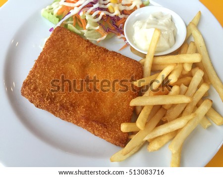 closeup fried fish, chips and salad on a white dish. Horizontal photo