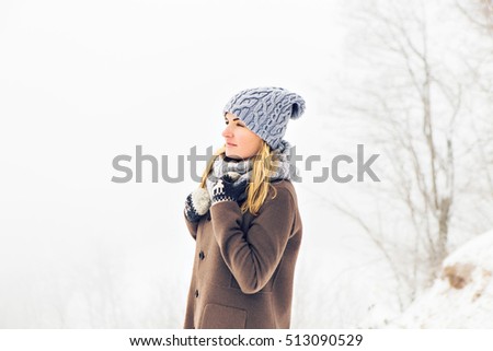 Attractive young woman in wintertime outdoor. Snow and cold