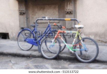 Street view with sport bicycles in blur. Personal bicycles parked on street. Old house and bicycles on walking street. Urban life blurred image for background. Everyday sport in city blurred template