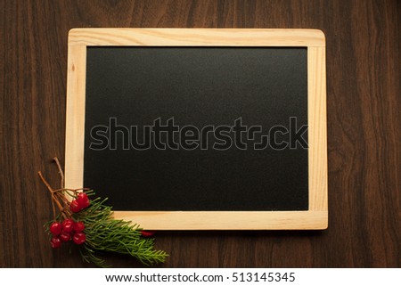 Chalkboard as background to write christmas and new year caption, decorated with branch of fir and rowan berry.