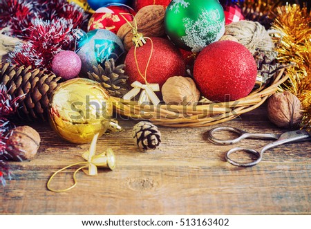 Christmas Composition with Gifts. Basket, red balls, pine cones, snowflakes on Wooden Table. Vintage style. toning