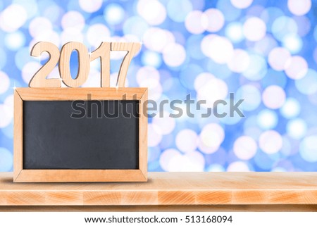 Blackboard menu on wooden table with blurred bokeh background, And copy space for adding your content happy new year 2017