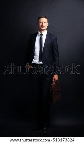 Handsome confident businessman on a dark background