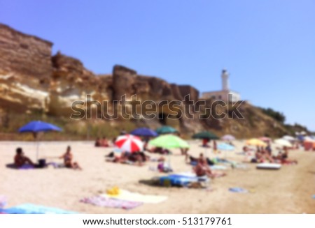 Italian beach with umbrellas. South Italy coastal lifestyle blurred photo. Summer vacation in Italy. Summer town beach blurry image for background or postcard. Romantic seaside picture in blur