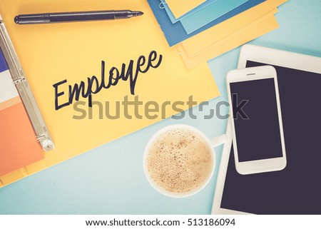 Notepad on workplace table and written EMPLOYEE concept