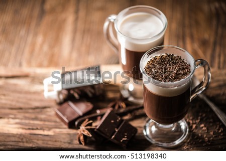 Irish coffee with grated dark chocolate on wooden table