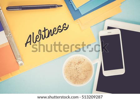 Notepad on workplace table and written ALERTNESS concept