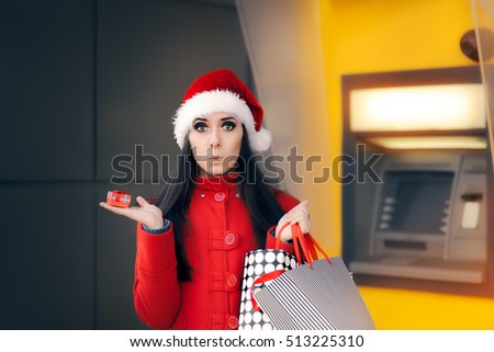 Girl holding Small Gift Box and Shopping Bags in front of an ATM - Funny woman with Santa hay holding holiday presents and gift bags
