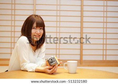 Young woman holding a camera with smile