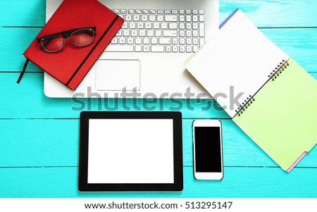 Electronic devices with copy space on blue wooden background. Notebook and work accessories. Top view 