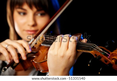 beautiful girl playing violin, selective focus on the front hand
