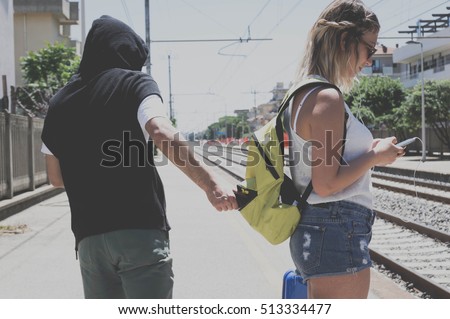 Thief is stealing the wallet to a girl at the station Royalty-Free Stock Photo #513334477