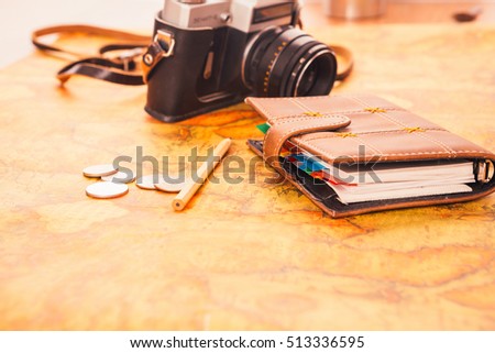 notebook, camera on the background  of vintage world map