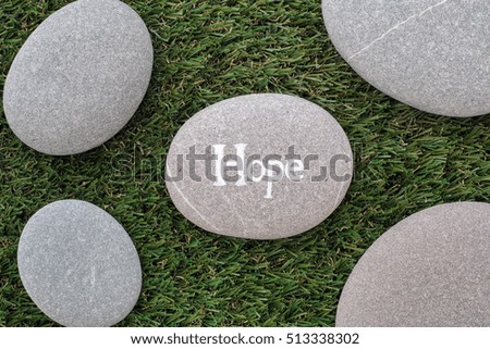 Hope. Bunch of stones lying on green grass. Close up.