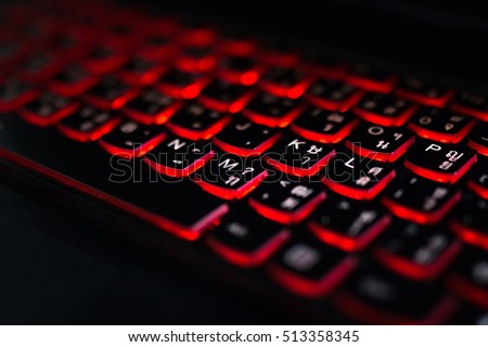 Close up. Red backlight, backlit on laptop or keyborad computer of gaming in the dark. Computer laptop keyboard with red dark backlight, backlit in the dark. Concept computer keyboard background.