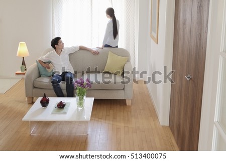 Husband turning round on sofa to look at wife