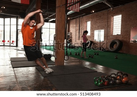 Bodybuilder using rings in gym