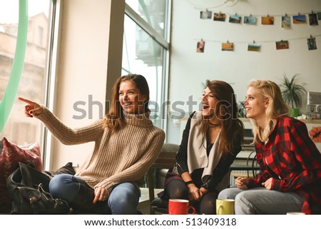 Girl showing something through the window her friends.